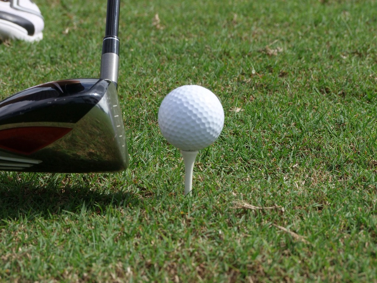 Close-up shot of a high-performance golf ball resting on a tee at a golf course