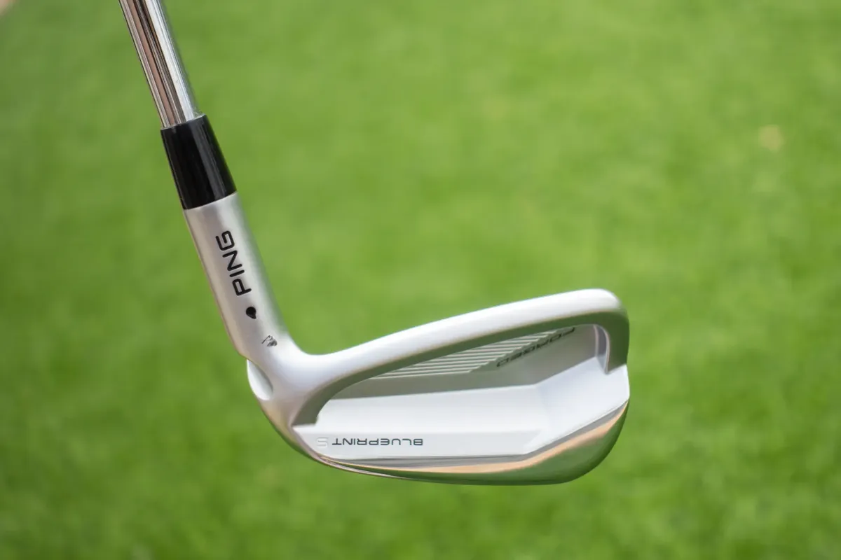 High-quality image of a Ping Blueprint golf iron on a grassy background.